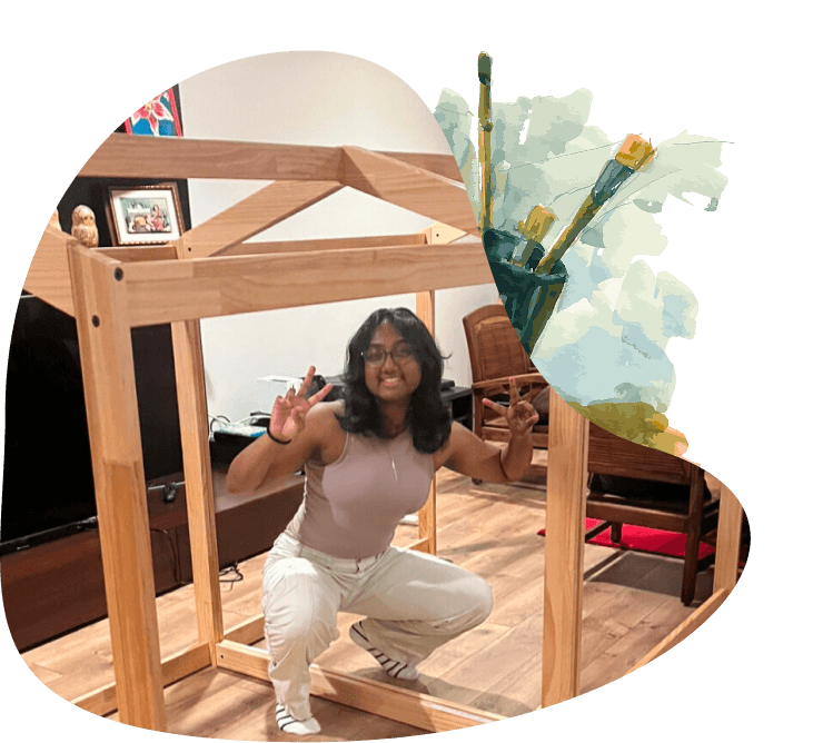 a woman squats in front of a wooden playhouse
