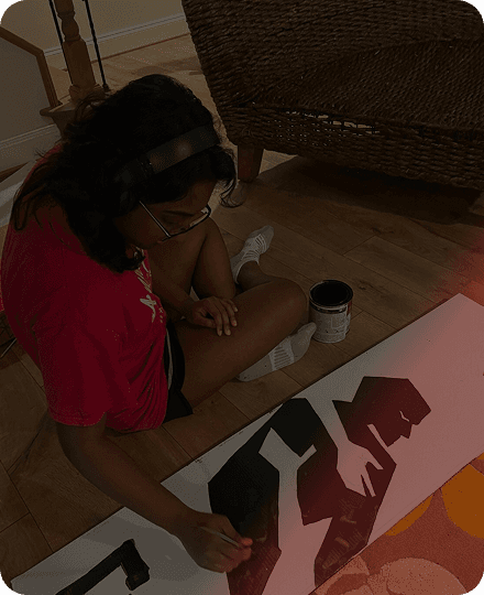 a girl paints a letter on a piece of paper